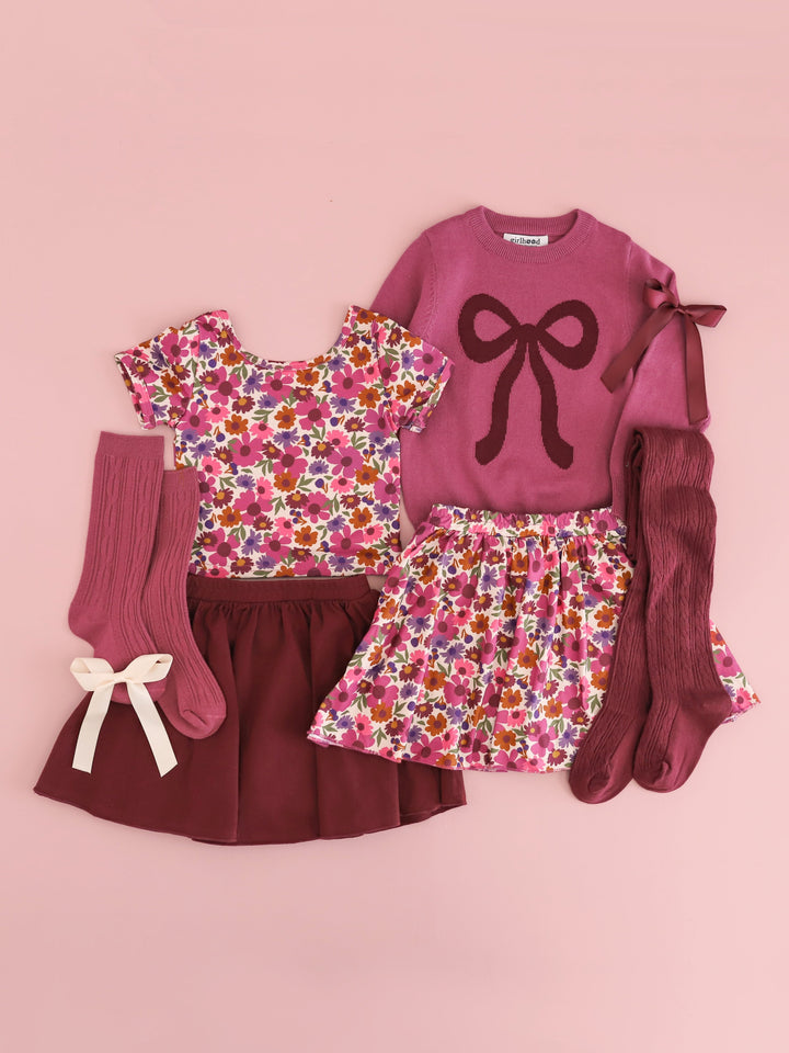 flat lay in shades of mauve and burgundy including autumn floral top and skort, solid burgundy skort, mulberry bow sweater with matching tights, socks and bows for fall