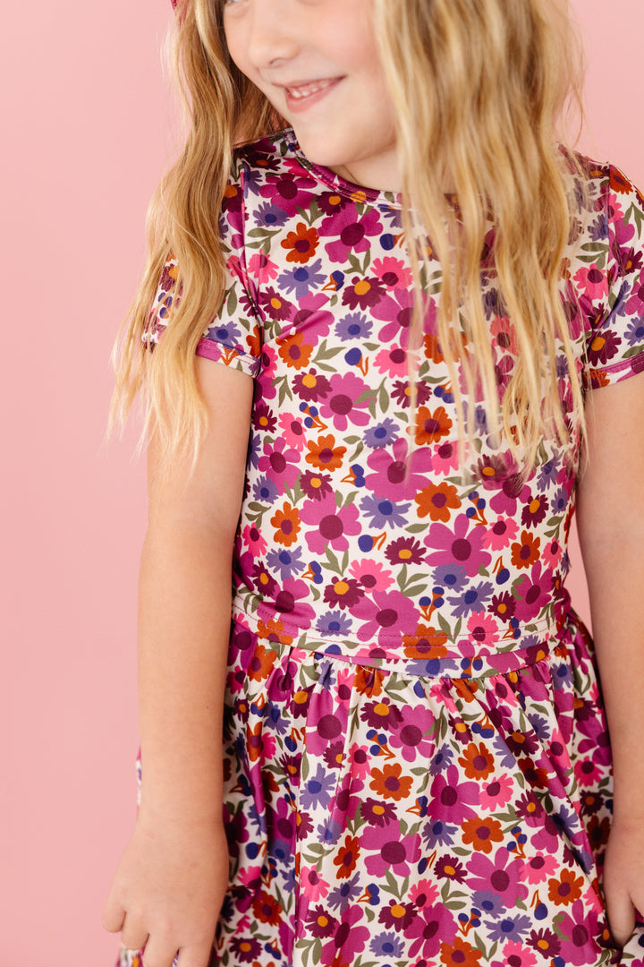 close-up of little girl in autumn floral in shades of fall pink paired with matching printed skort