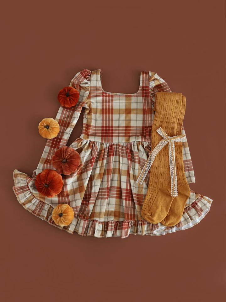 styled fall flatlay photo for girl's velvet long sleeve twirl dress with cream base and burnt orange and mustard plaid paired with mustard cable knit tights and matching lace bow