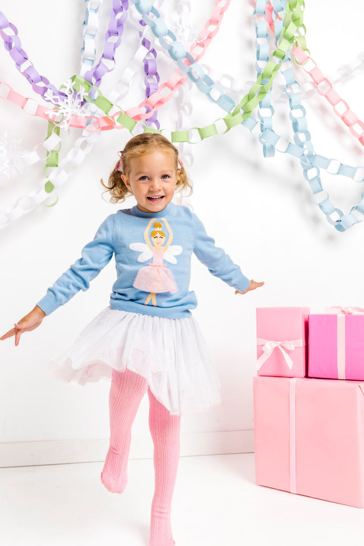 little girl dancing in blue ballerina knit sweater paired with sparkly white tutu skit and pink open knit tights for winter wonderland