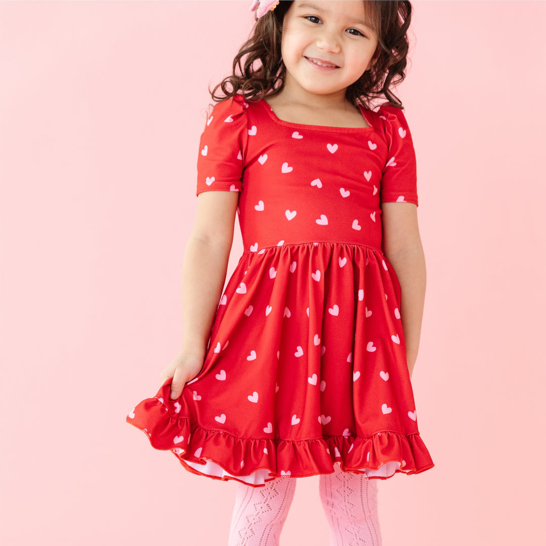 closeup of valentine's red twirl dress with pink hearts