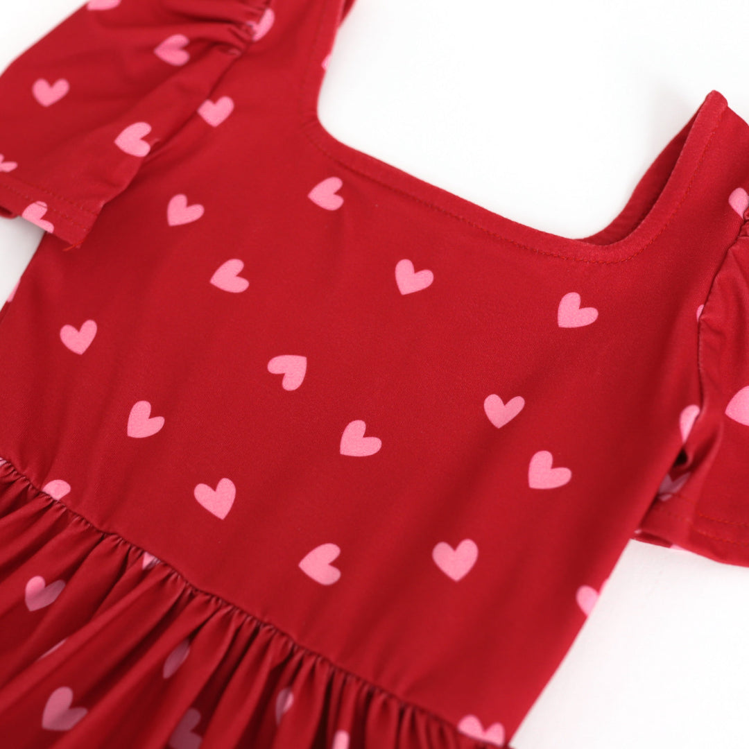 detail photo of red twirl dress with pink heart print