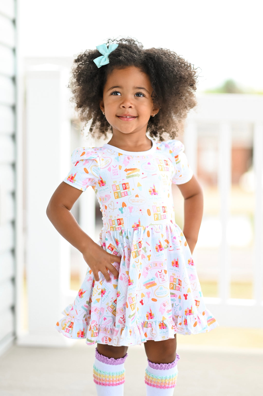 little girl wearing disneyland inspired twirl dress and matching blue bow