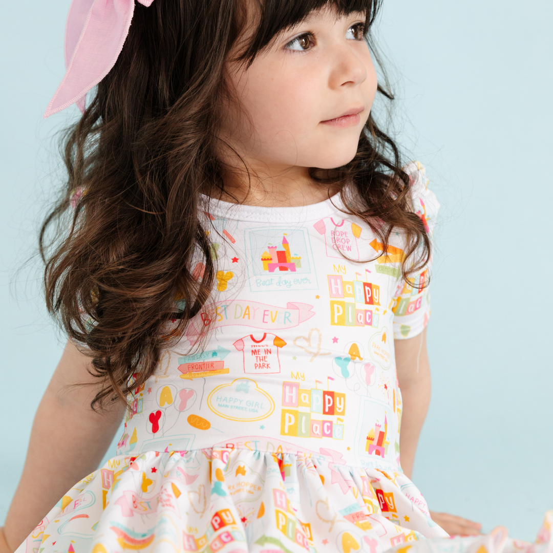little girl wearing pink bow and disneyland inspired twirl dress