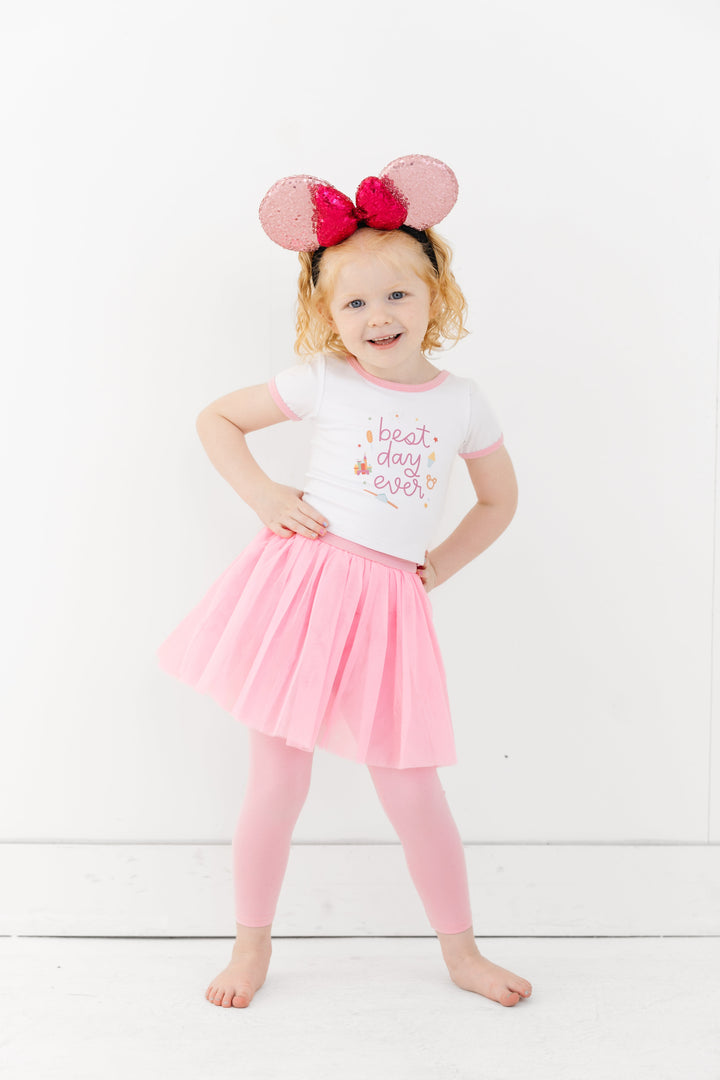 little girl in sparkly pink Minnie ears, best day ever top and matching light pink tulle skirt with attached leggings for park days