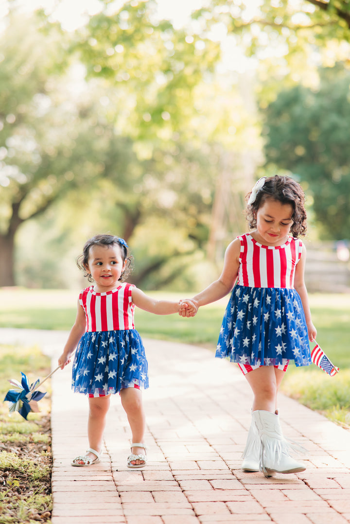 sisters in matching 4th of july stars and stripes tutu sets with matching red striped shorts