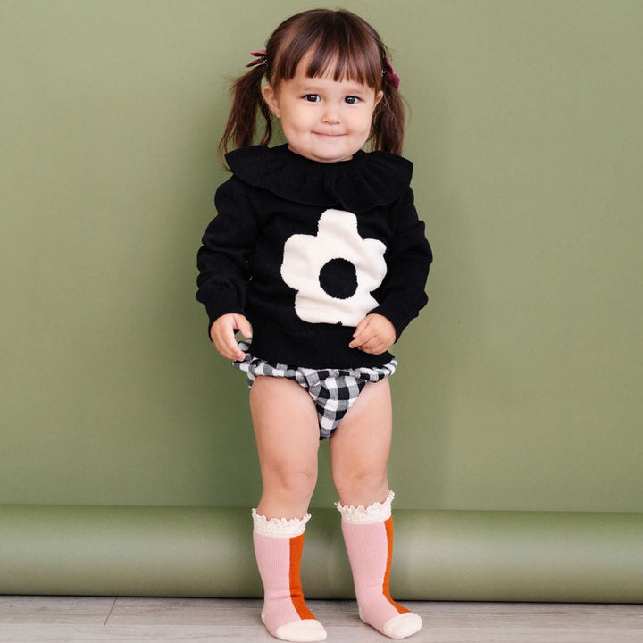 toddler girl wearing black knit sweater with big flower
