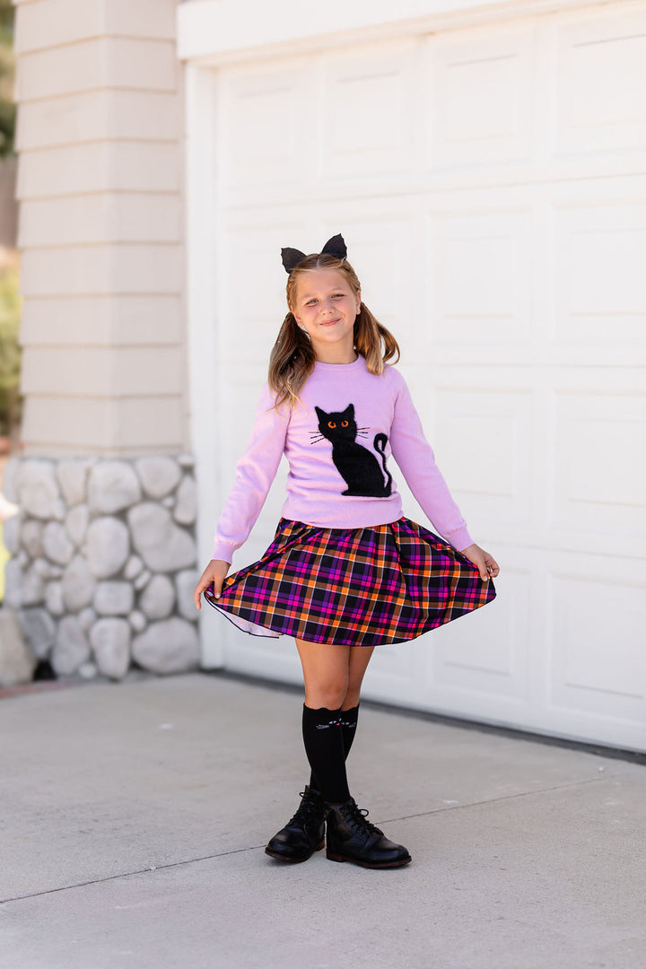 young girl wearing cat ears in purple pullover sweater with fluffy black cat design, matching plaid skort and black cat knee highs