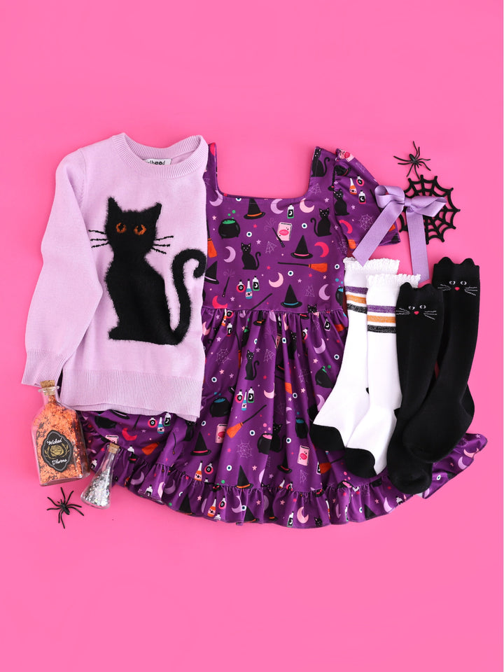 girls' dark purple square neck twirl dress with witch inspired print, light purple pullover knit sweater with fluffy black cat design and matching socks and bow