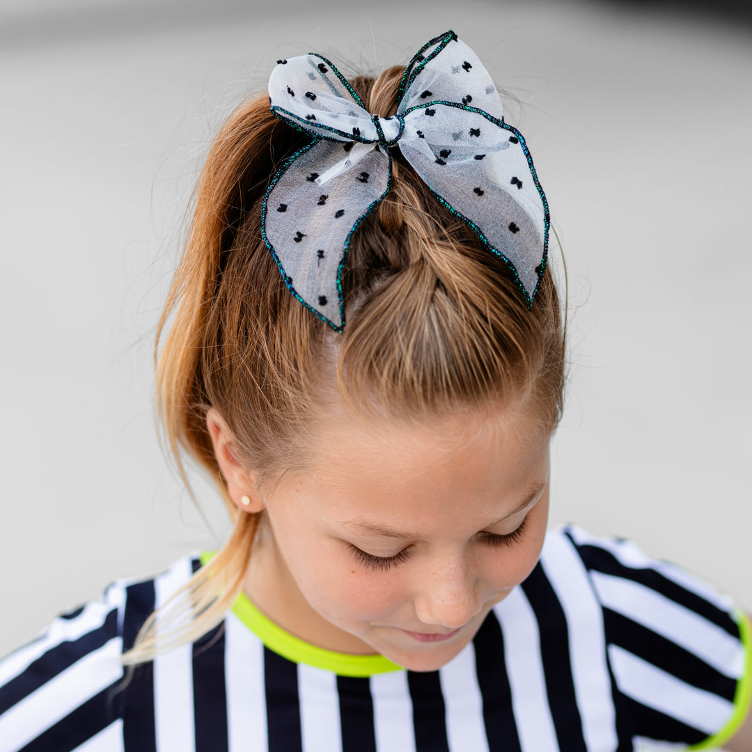 girl in sheer white with black dot and sparkly black trim bow paired with Beetlejuice inspired black and white striped Halloween top