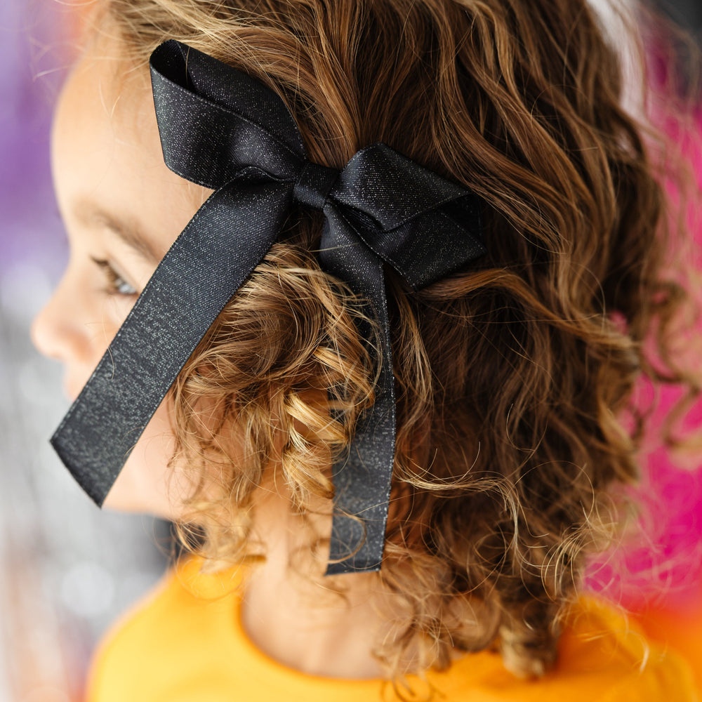 little girl in black shimmery ribbon bow on clip for Halloween