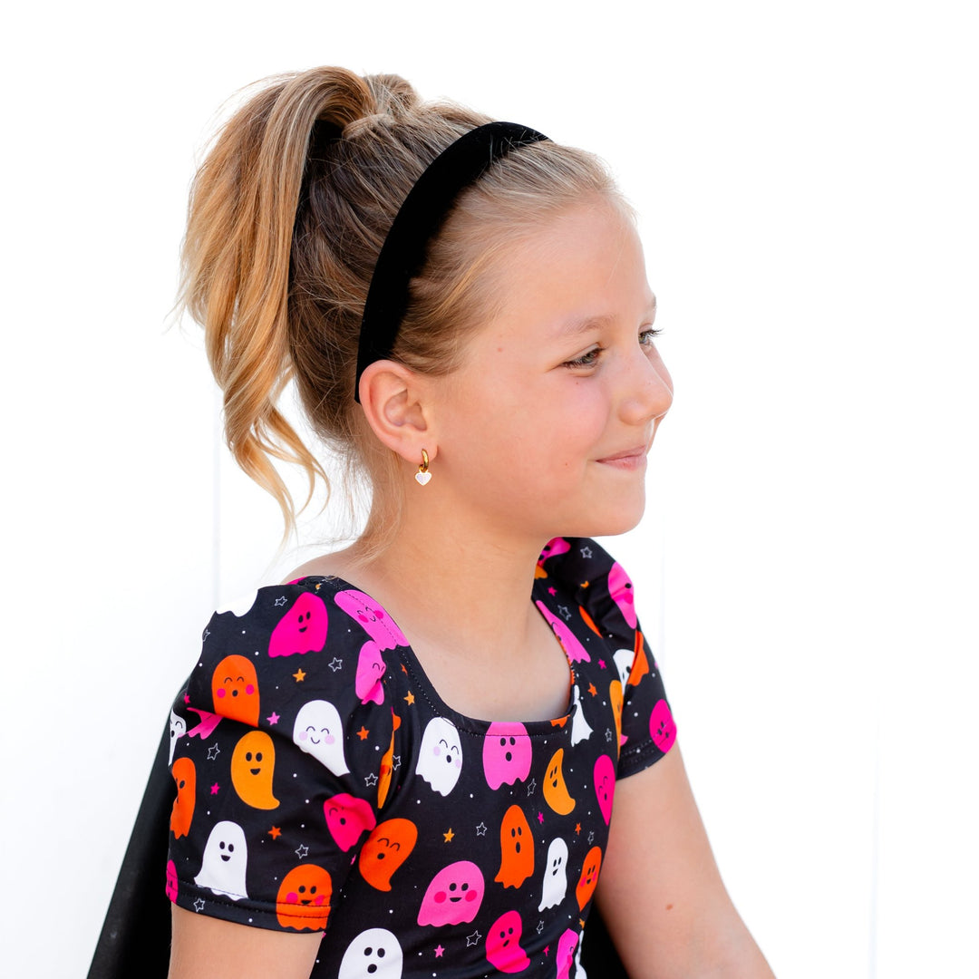 little girl in solid black velvet headband with matching ghost print twirl dress