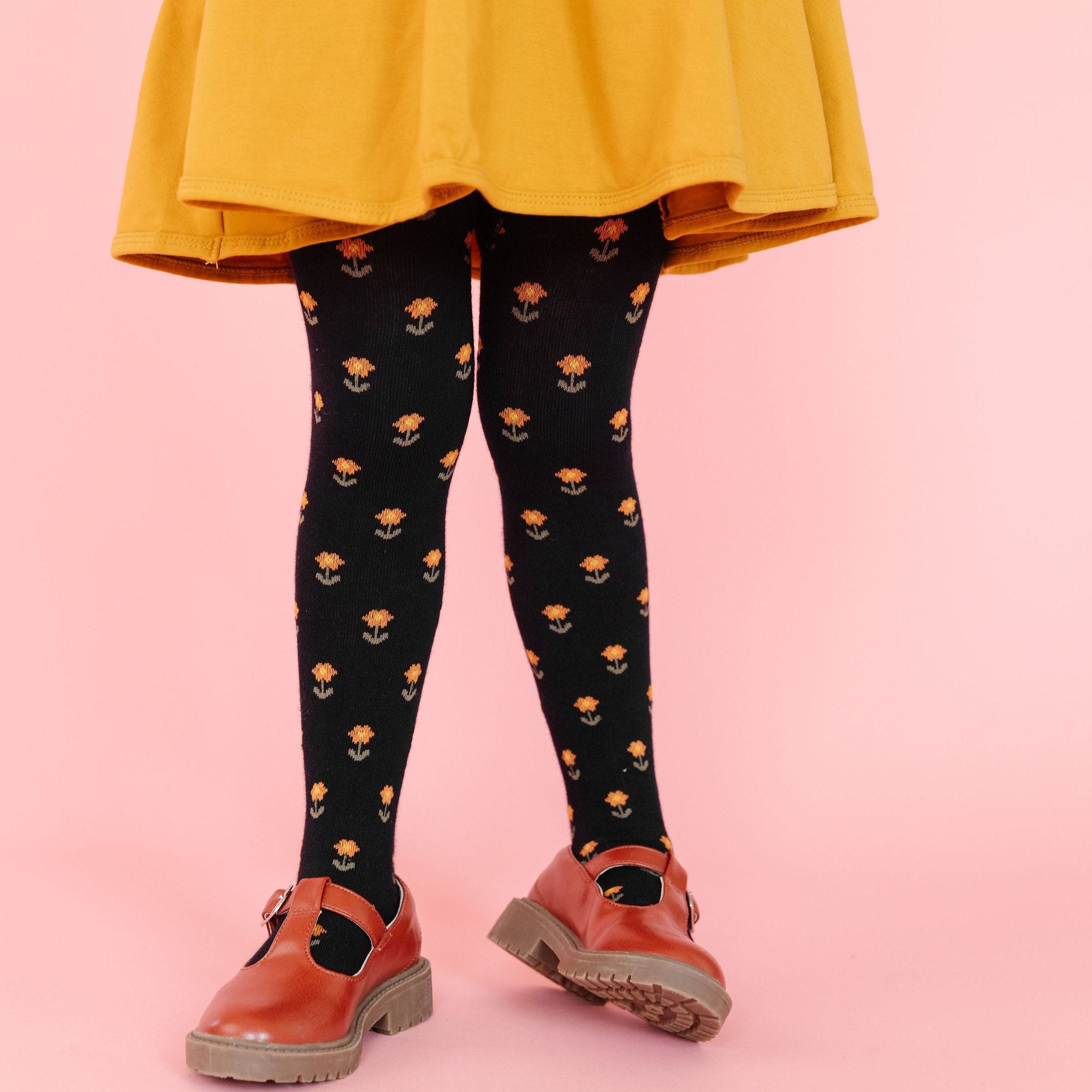 little girl in yellow dress and black floral tights