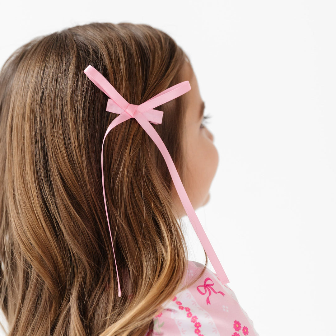 girl in light pink satin ribbon bow with long tails and covered alligator clip for spring and easter