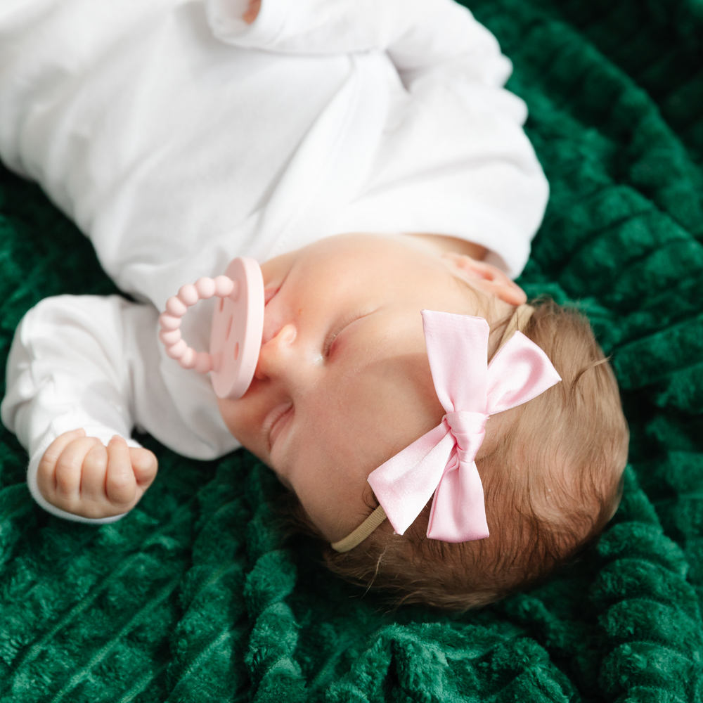 baby girl wearing light pink satin hair bow