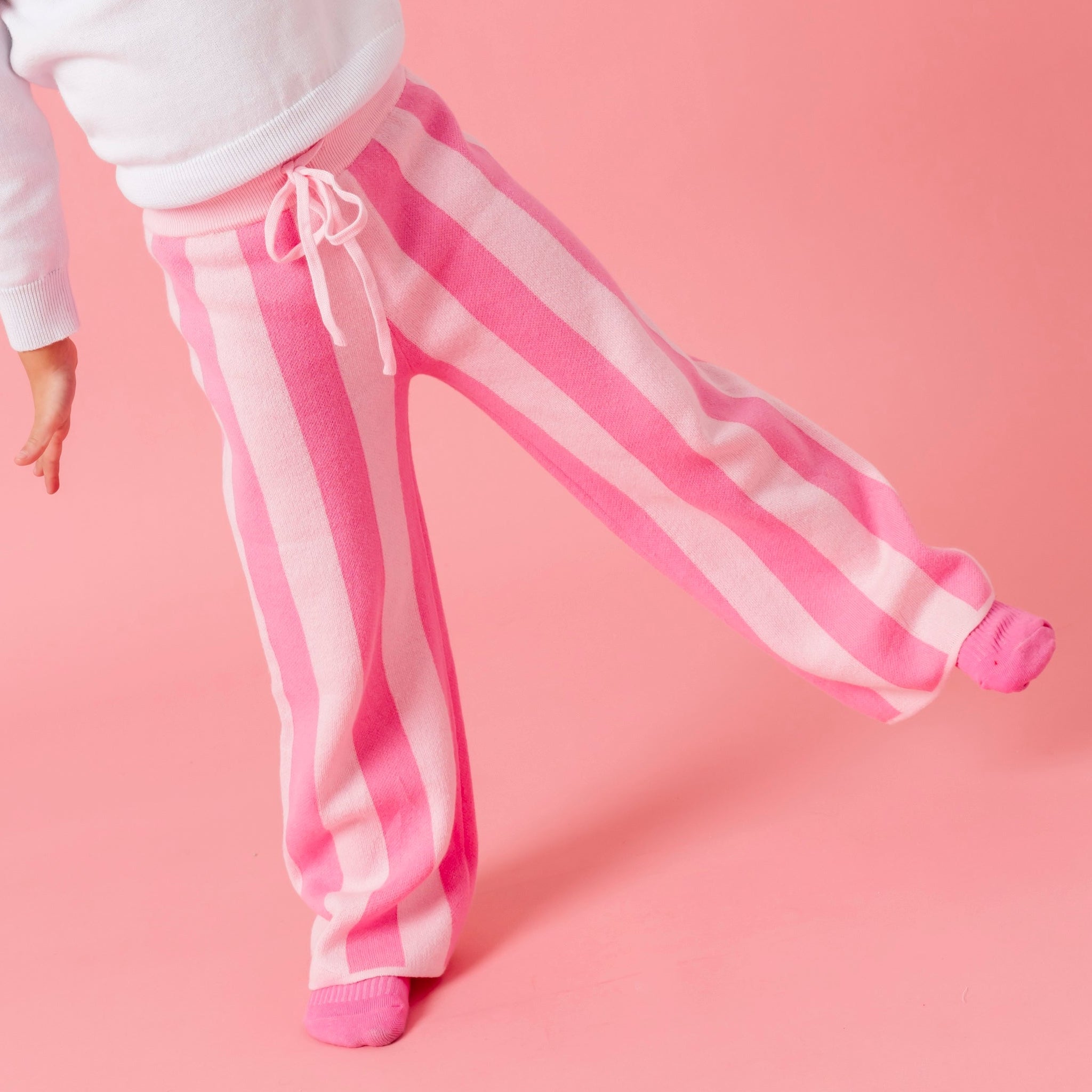 girl in two tone pink striped cotton knit sweater pants and pink socks