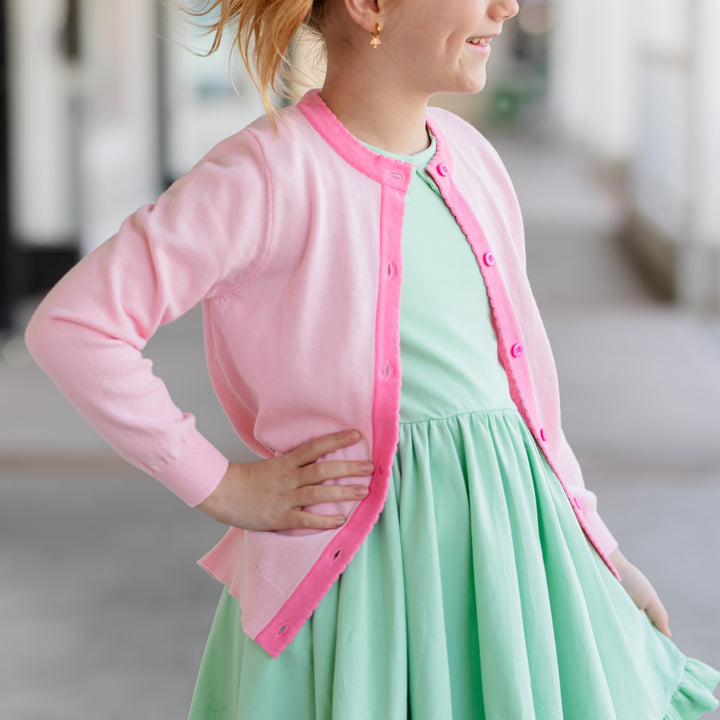 girl in pink cardigan with darker pink scallop edge and spring mint green twirl dress