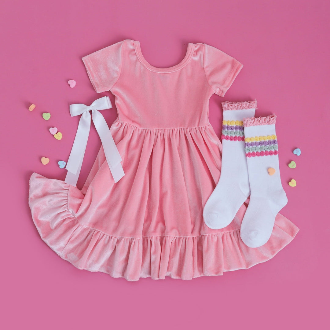 girls pink velvet twirl dress with pastel stripe knee highs and white satin bow for Valentine's Day