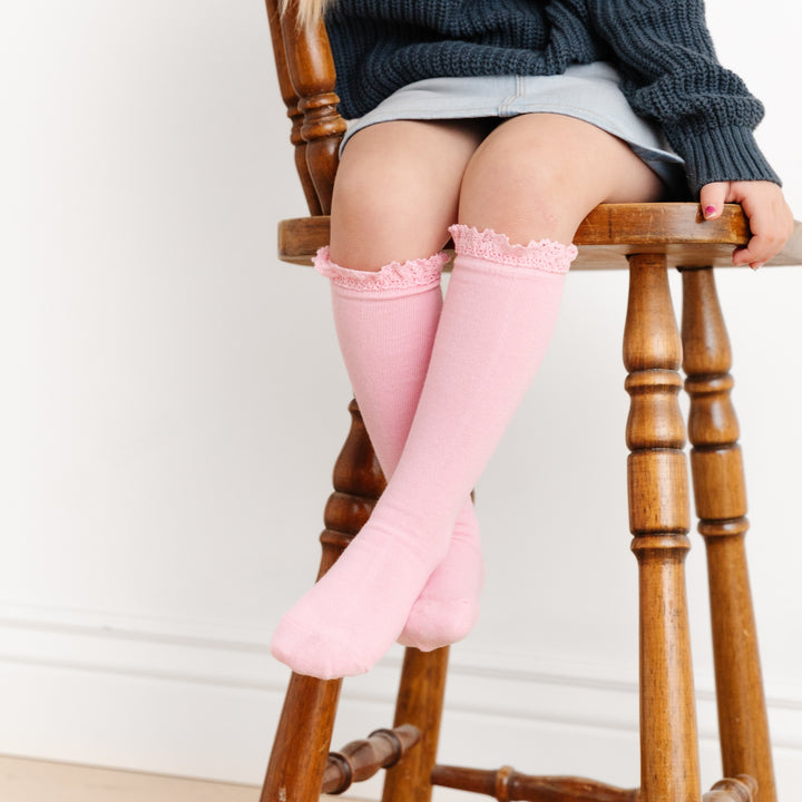 sitting girl with corssed legs wearing blossom pink vintage lace top knee high socks