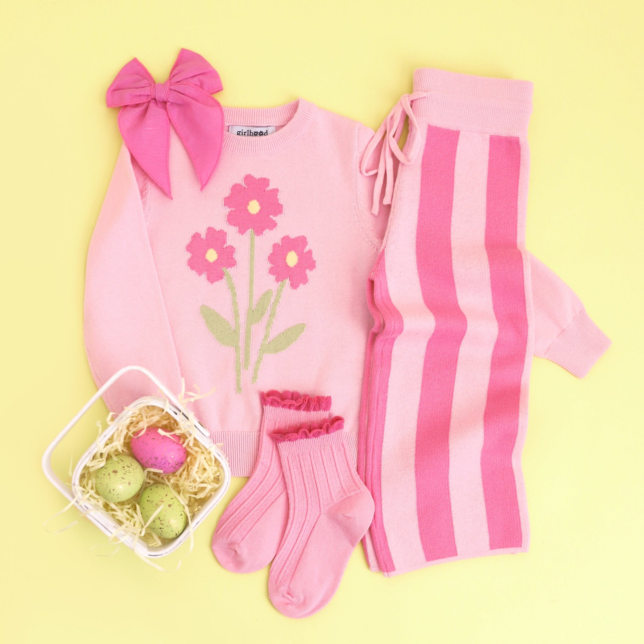 girl's styled spring sweater outfit with pastel pink flower pullover, pink striped sweater pants and matching midi socks and hair bow