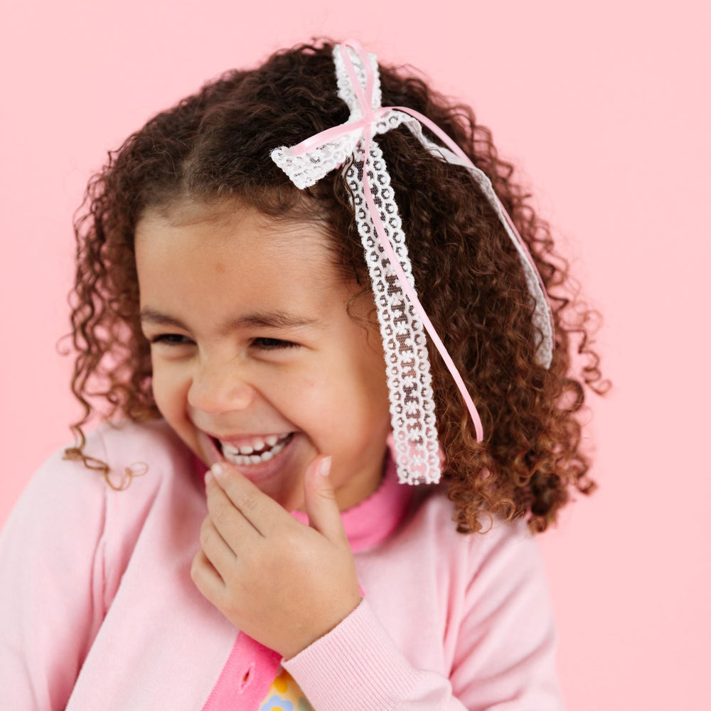 little girl in spring double hairbow with dainty light pink satin ribbon layered over white lace to match two-tome pink cardigan