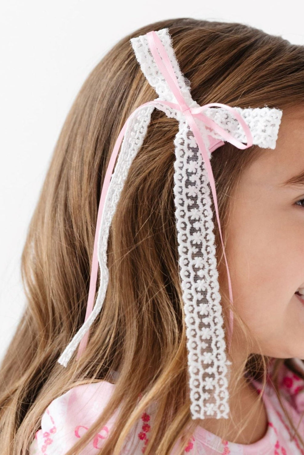 little girl in double white lace and pink satin hairbow and matching pink bow wallpaper print twirl dress for spring and easter