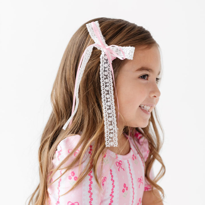 little girl in double white lace and pink satin hairbow and matching pink bow wallpaper print twirl dress for spring and easter