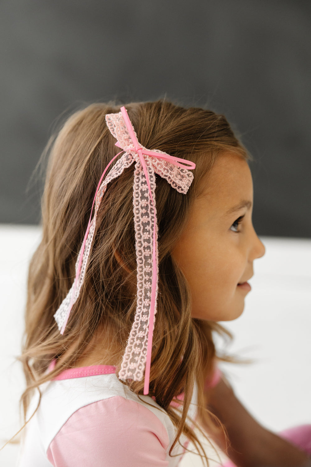 little girl in two tone pink lace and ribbon double bow on alligator clip
