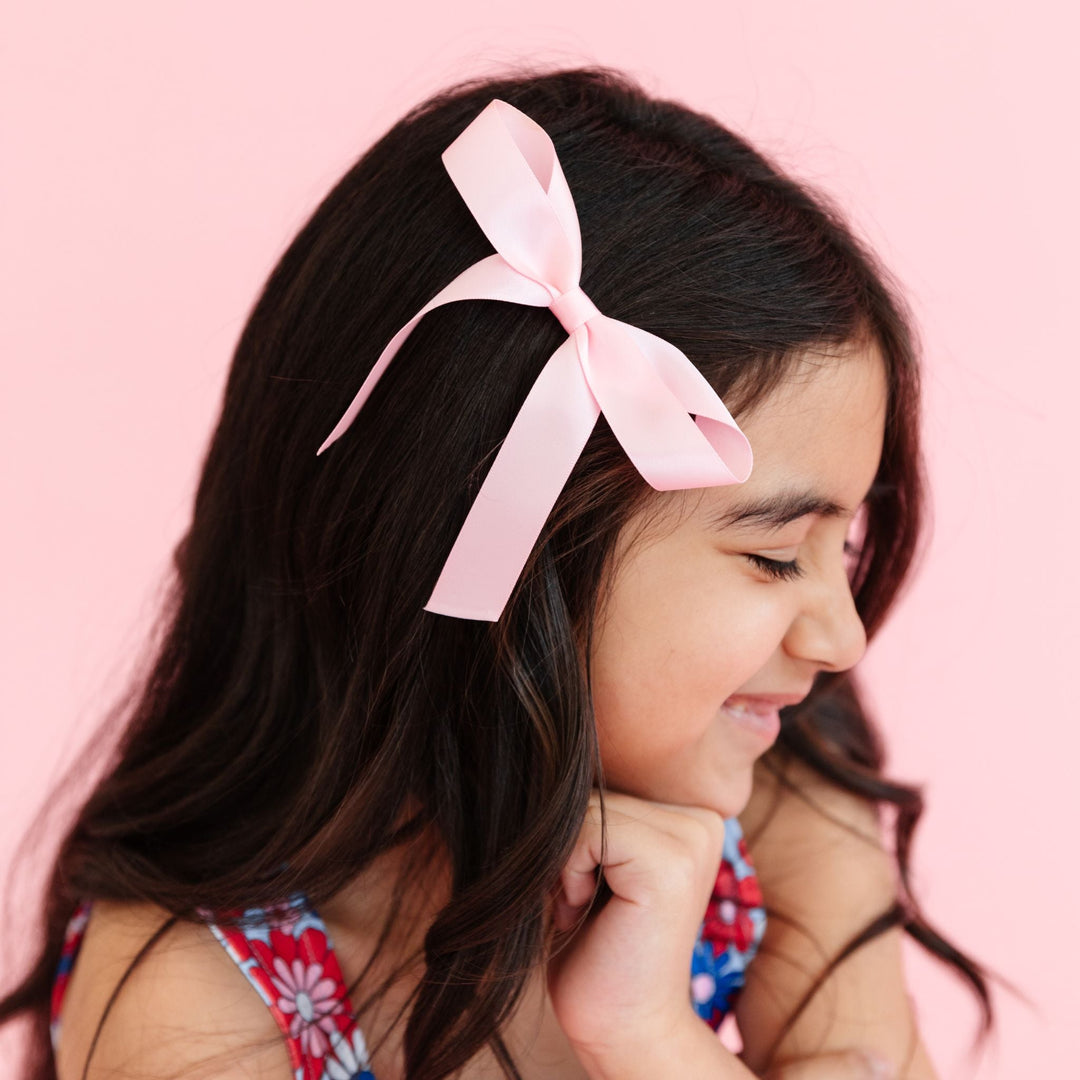 little girl with light pink satin ribbon bow on clip to match 4th of July floral print twirl dress