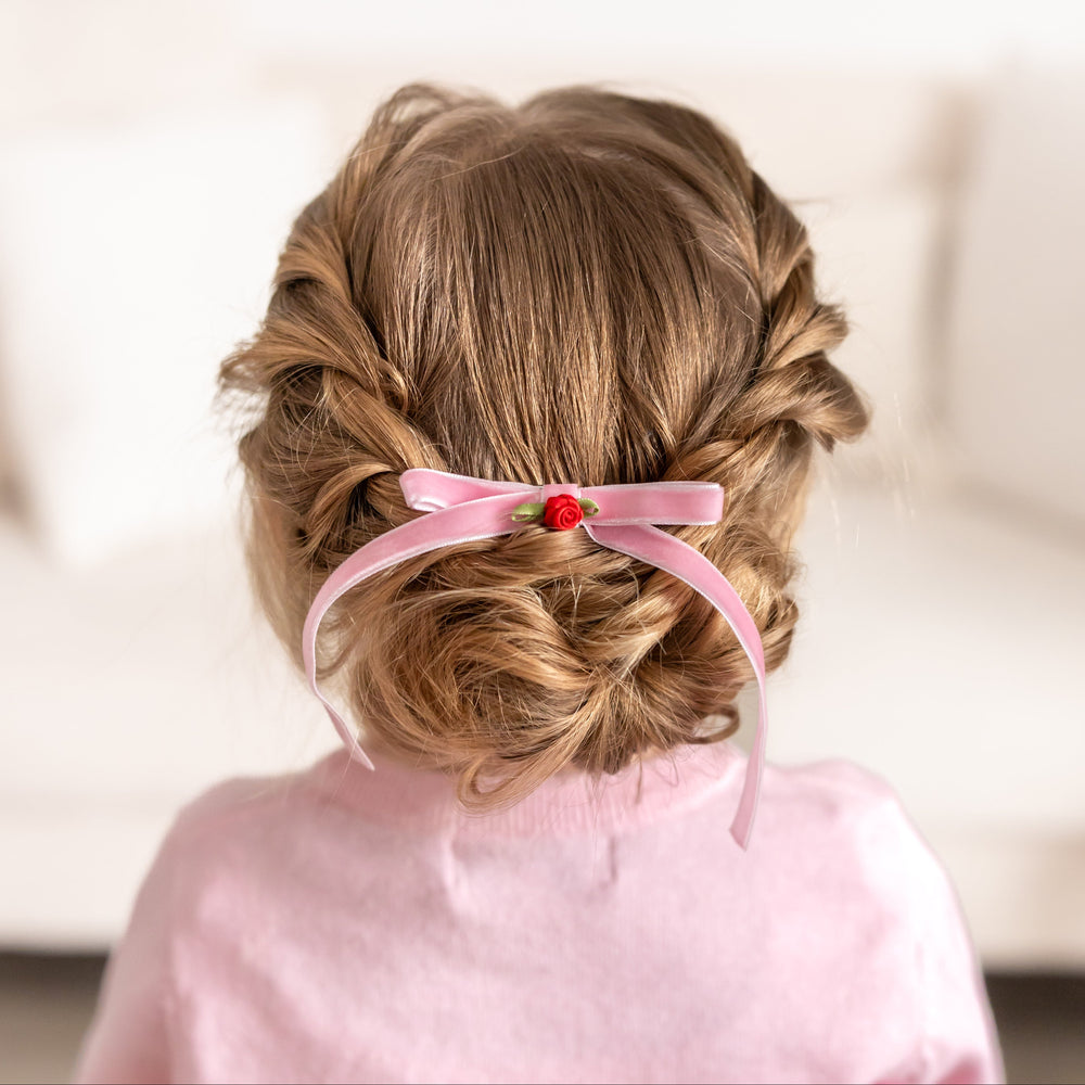 little girl with dainty pink velvet hair bow on clip with petite red rosette embellishment