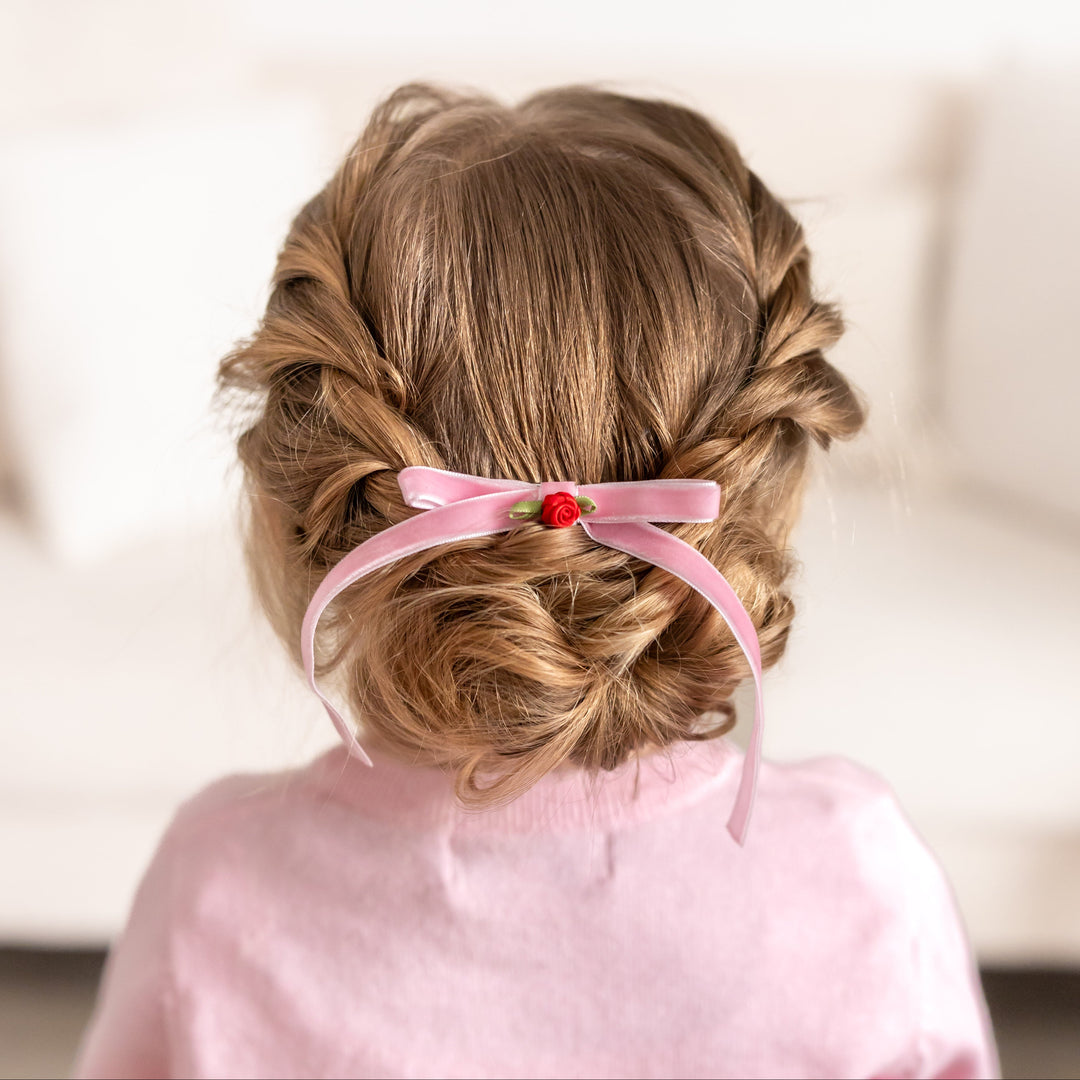 little girl with dainty pink velvet hair bow on clip with petite red rosette embellishment