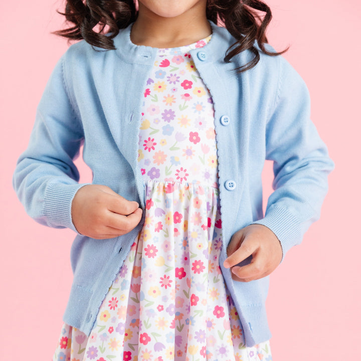 little girl in white floral twirl dress paired with blue cotton knit button up cardigan for spring