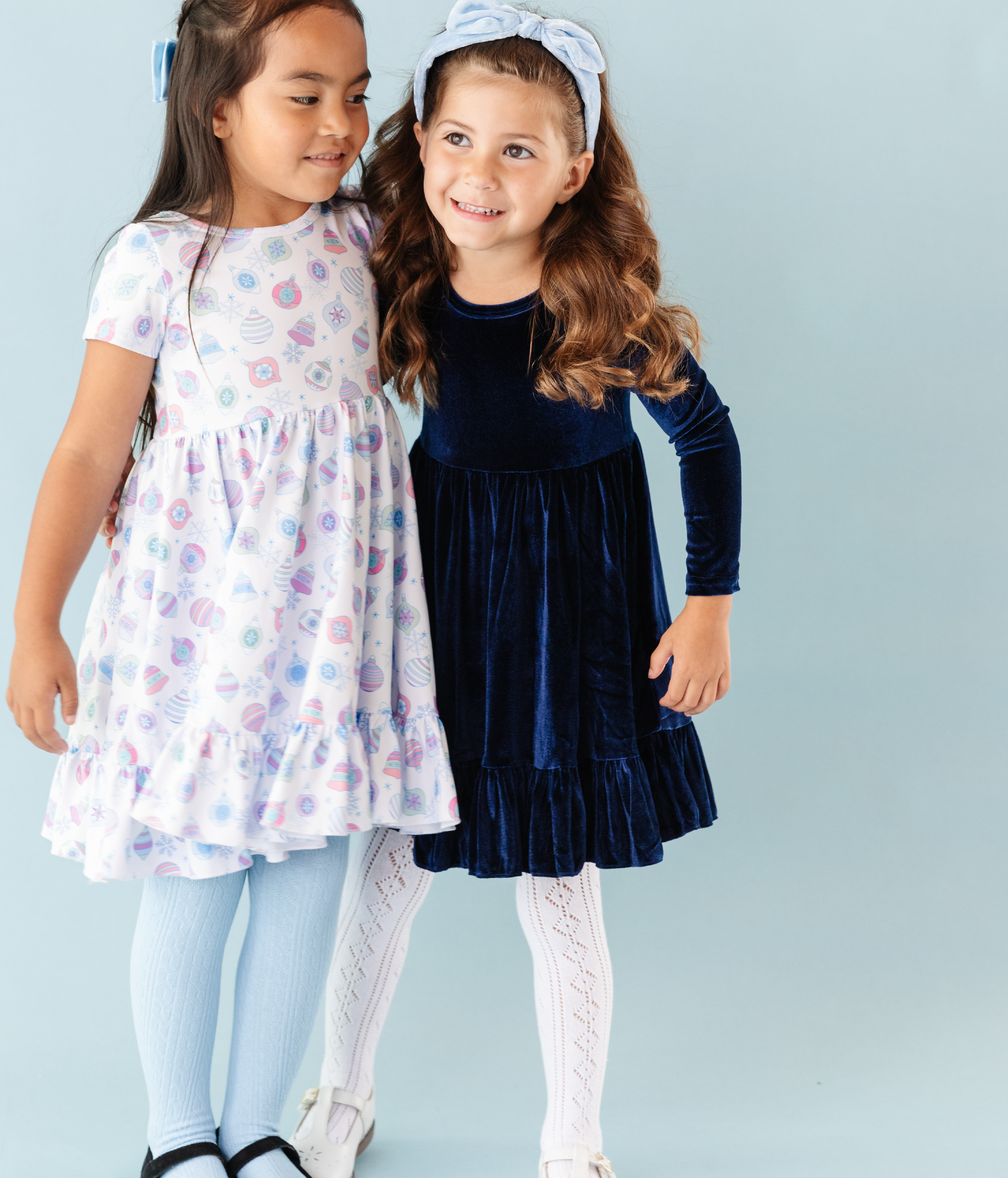 girls in pastel ornament print dress and dark blue velvet holiday dress