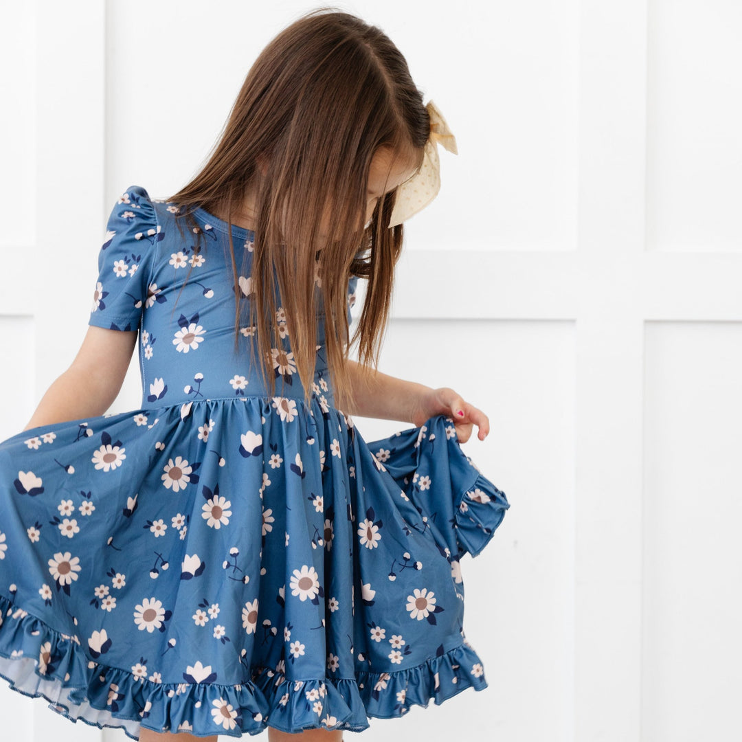 little girls holding skirt of blue floral twirl dress