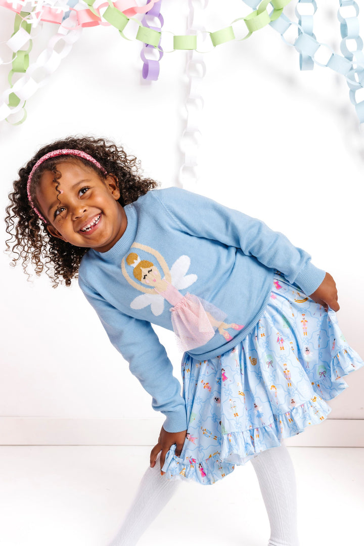 little girl in blue nutcracker print twirl dress paired with blue pullover sweater featuring ballerina sugar plum fairy wearing sparkly tutu