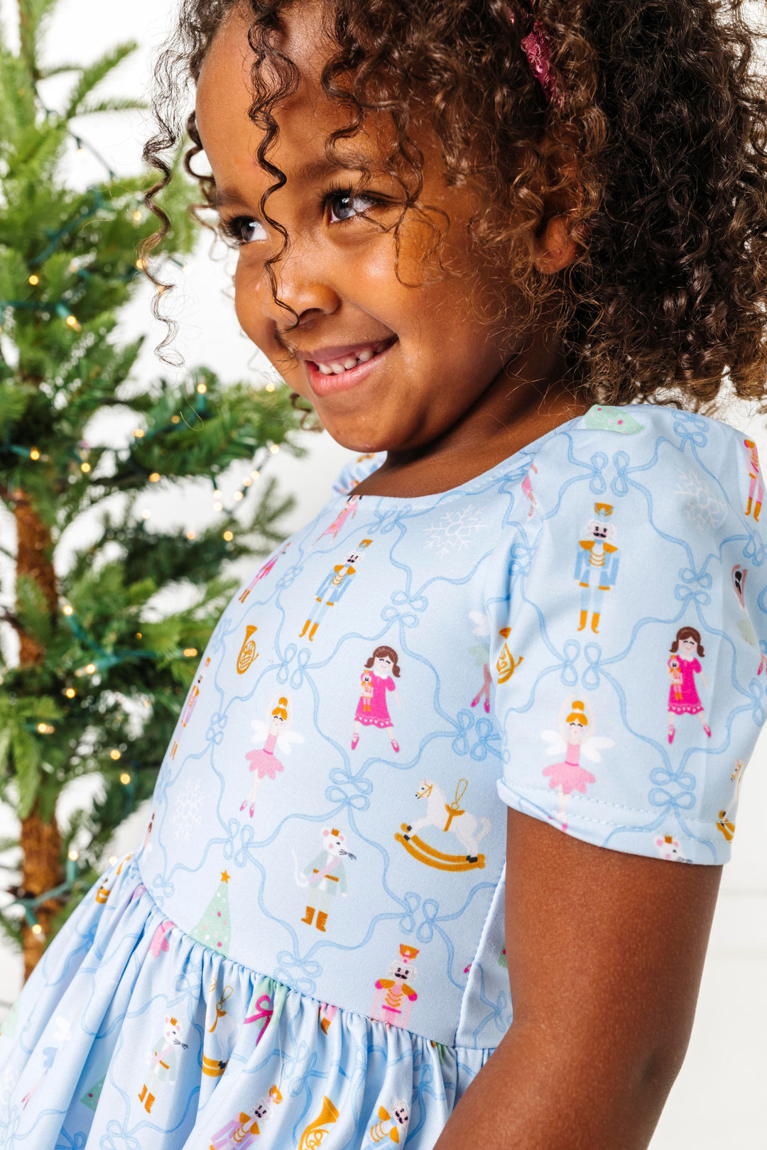 young girl in blue Christmas twirl dress with nutcracker and ribbon design