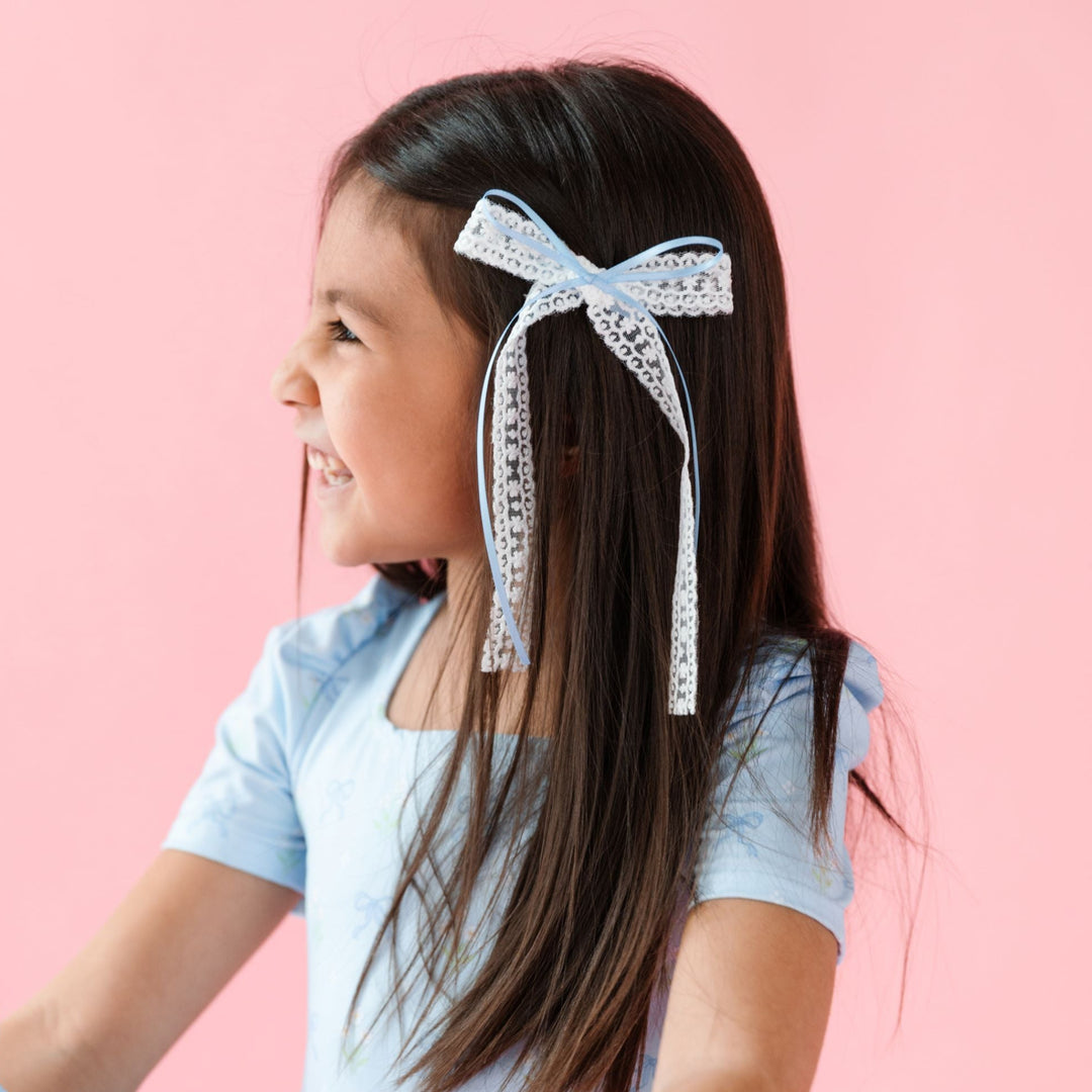 little girl in white lace long tail hairbow with blue ribbon overlay and matching spring blue bow print twirl dress 