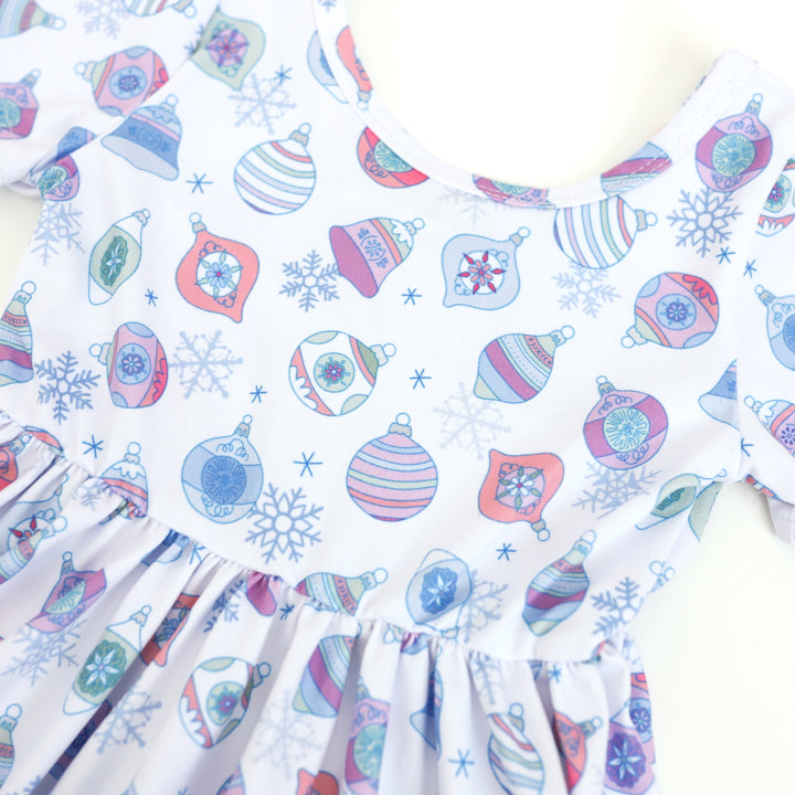 closeup of little girls winter ornament print twirl dress in pastel colors