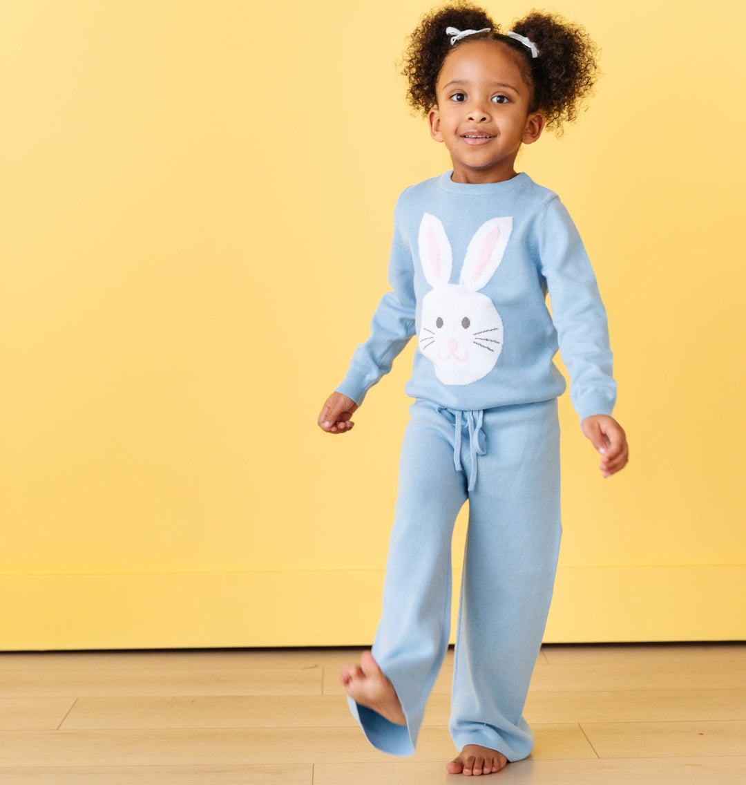 girl wearing spring blue knit drawstring pants and matching pullover sweater with white bunny