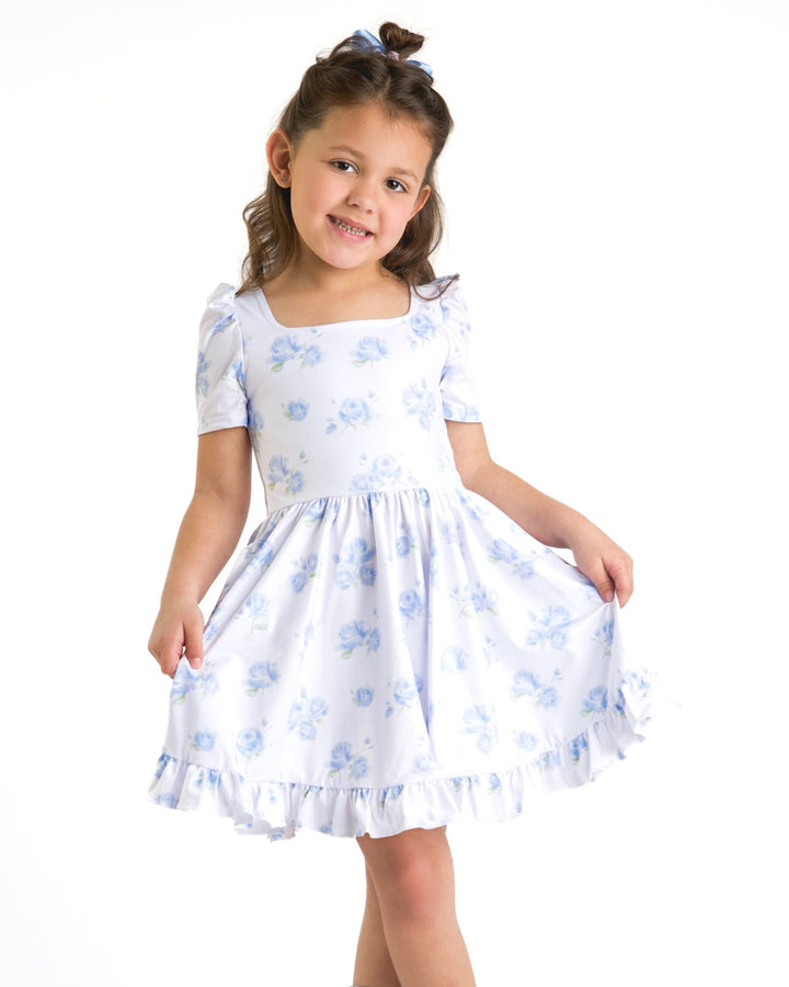 little girl in white square neck twirl dress with pretty pastel blue rose design for spring
