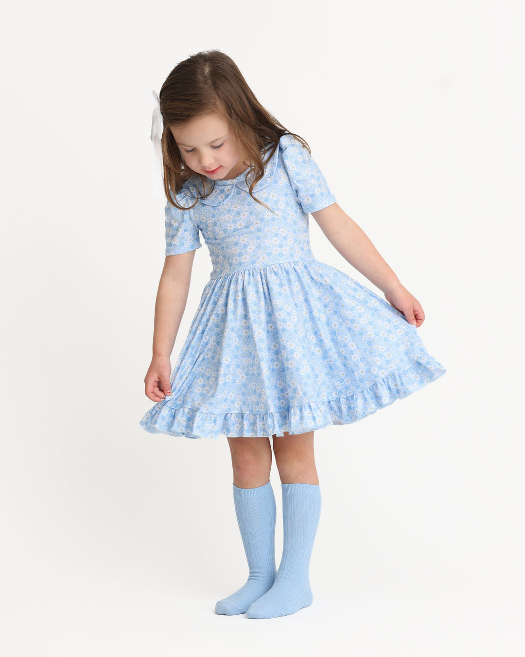 young girl in pastel blue micro floral twirl dress with peter pan collar and matching blue cable knit knee socks for spring