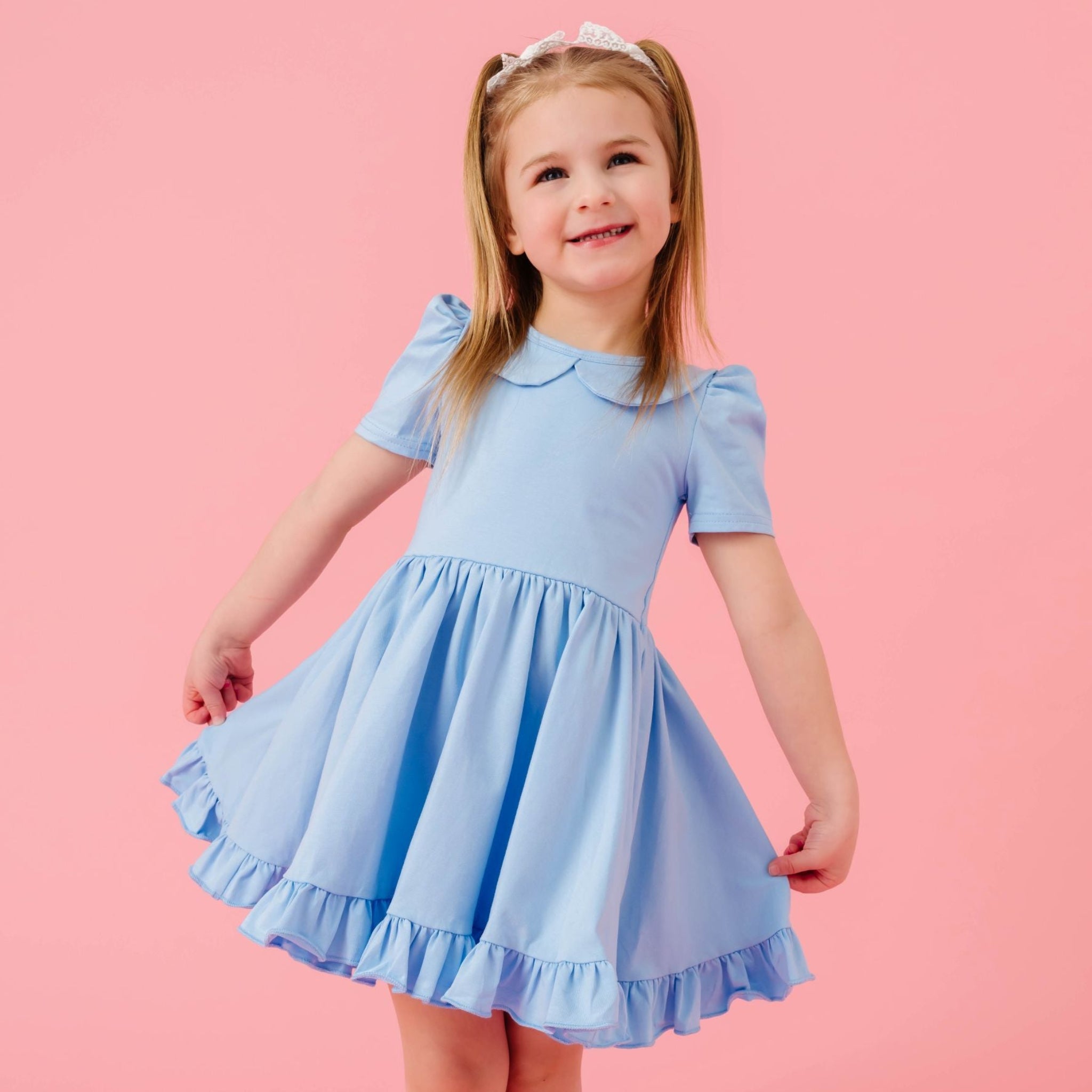little girl in spring blue cotton knit twirl dress with peter pan collar and ruffled trim for spring