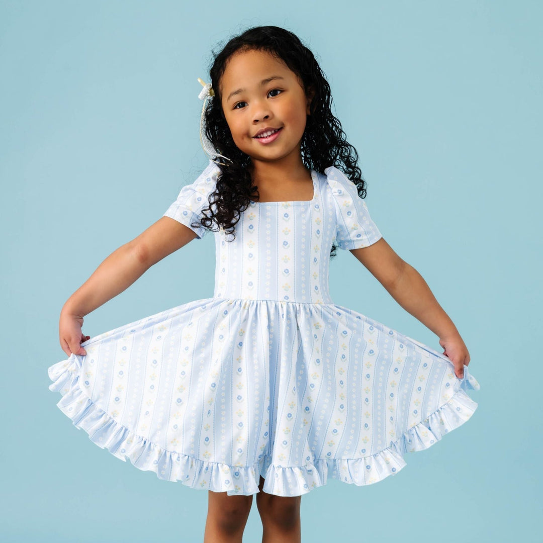 little girl in blue and white floral wallpaper inspired spring print twirl dress with short sleeves and square neckline
