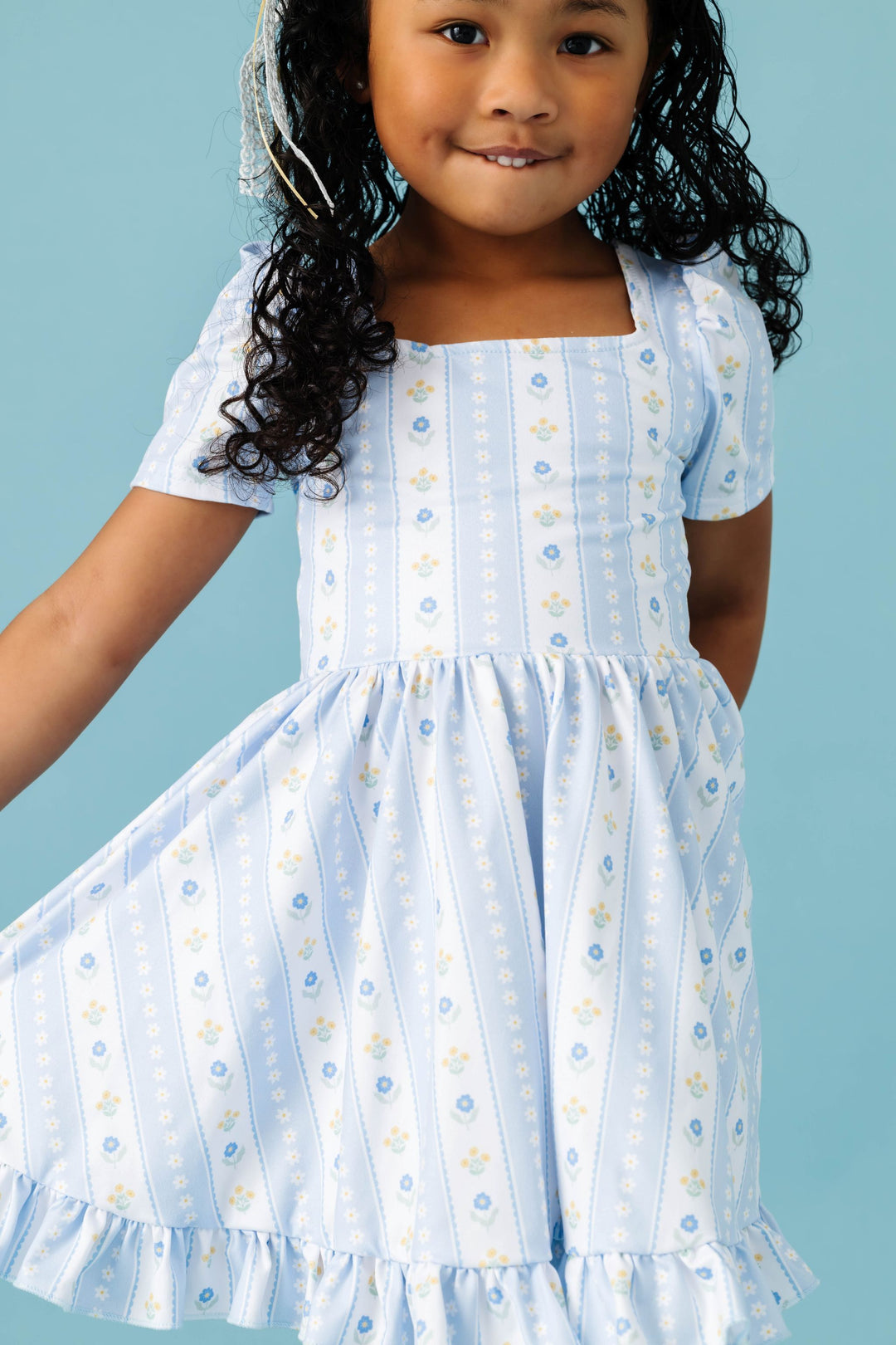 print detail photo of little girl in pastel blue and white wallpaper inspired twirl dress for spring