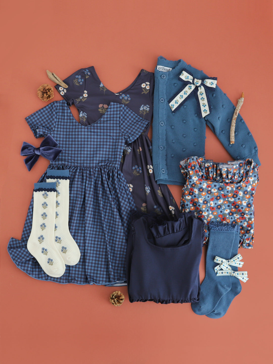 flat lay photo of coordinating dresses, sweaters, socks and bows in shades of blue for fall