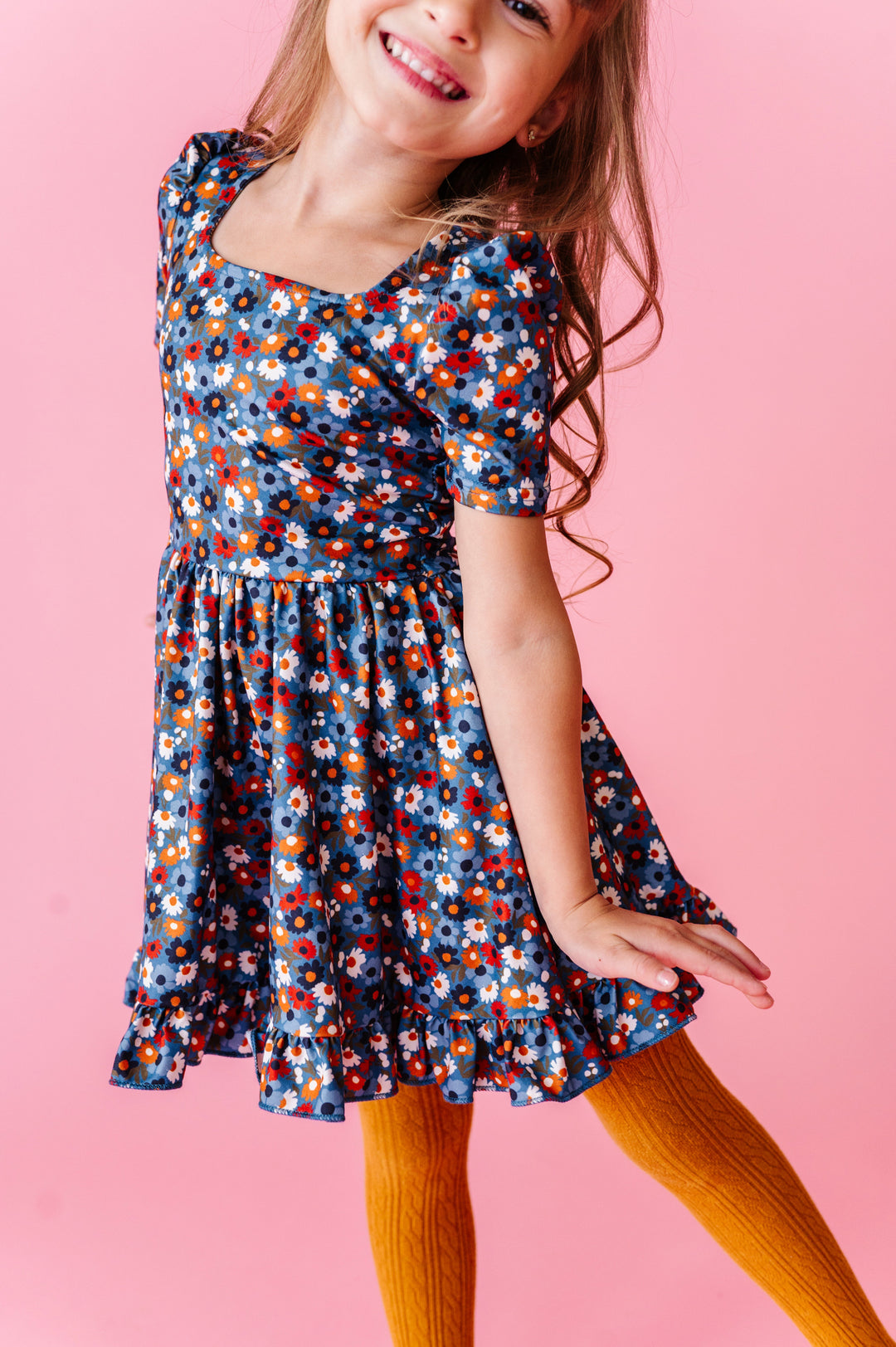 young girl in blue fall floral print twirl dress paired with matching mustard cable knit tights