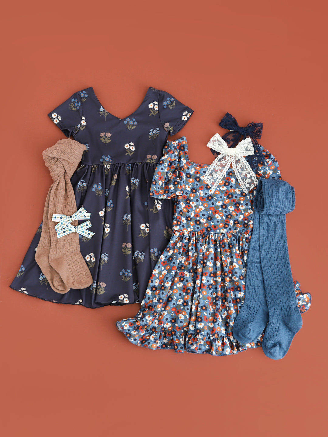 coordinating girls fall floral dresses in shades of blue paired with matching tights and lace hair bows
