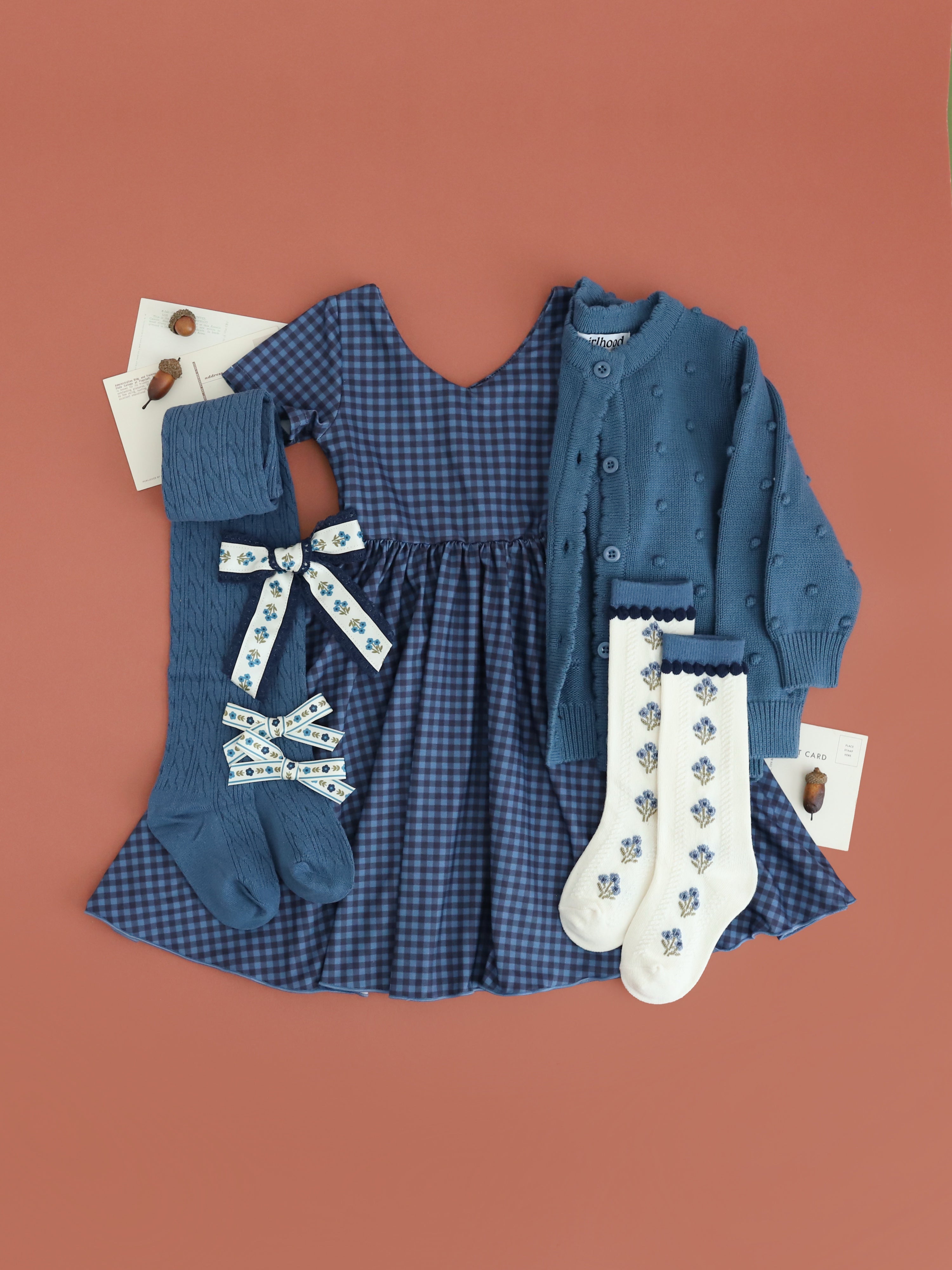 girls' blue gingham v-neck twirl dress styled with matching cardigan, tights, floral knee socks and hair bows for fall