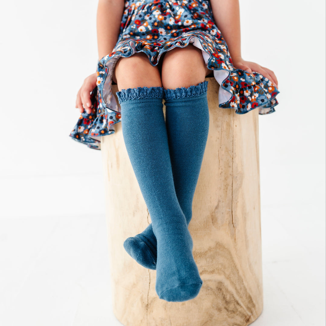 young girl in blue knee highs with lace trim paired with made to match blue floral twirl dress