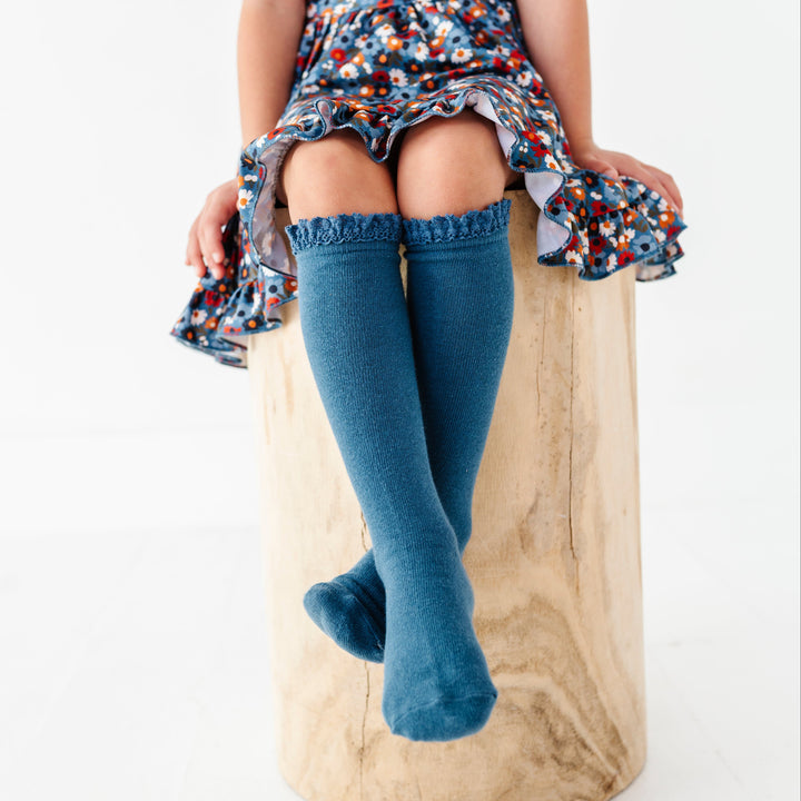 young girl in blue knee highs with lace trim paired with made to match blue floral twirl dress